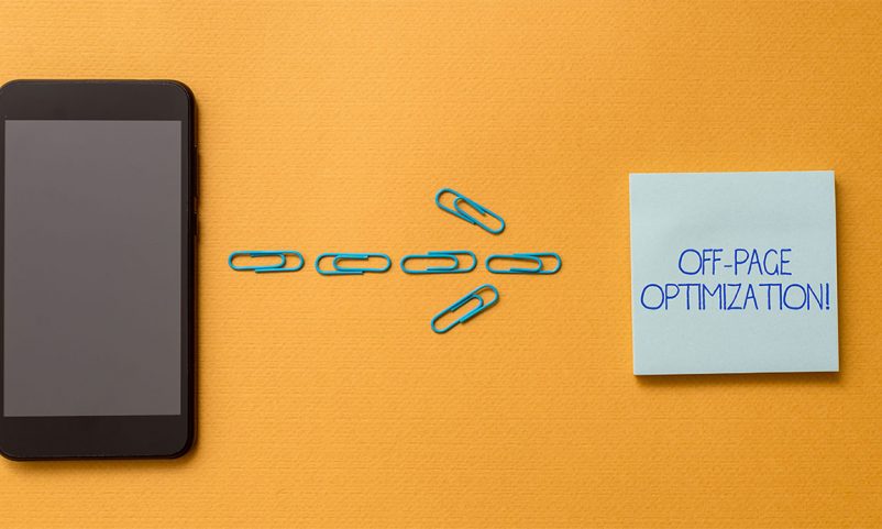 A mobile phone and paper clips shaped as an arrow pointing towards a piece of paper